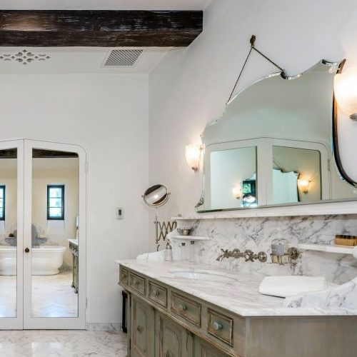 a bathroom with double sinks and mirrors with lights above the sinks