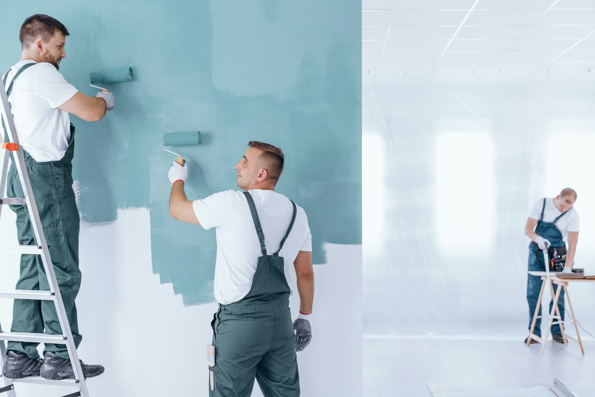 Men painting empty home interior