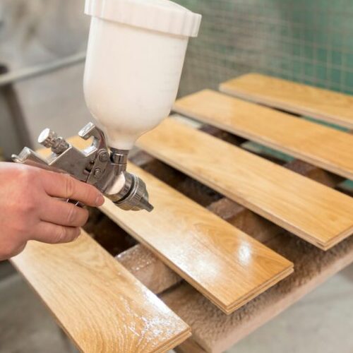 the master varnishes a wooden board